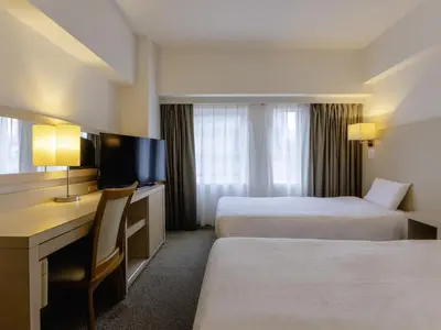 a hotel room with two beds and a desk at KOKO HOTEL Tokyo Nishikasai in Tokyo