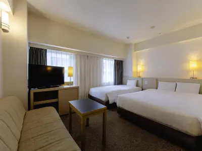 a hotel room with two beds and a flat screen tv at KOKO HOTEL Tokyo Nishikasai in Tokyo