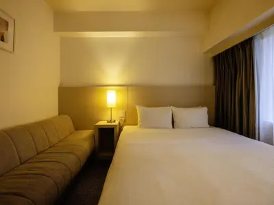a hotel room with a bed and a couch at KOKO HOTEL Tokyo Nishikasai in Tokyo