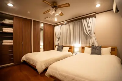a bedroom with two beds and a ceiling fan at UNITEDCUBE STAY TOKYO Private urban vacation home in Tokyo
