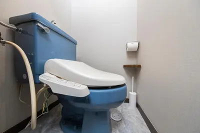 a bathroom with a blue toilet in a stall at UNITEDCUBE STAY TOKYO Private urban vacation home in Tokyo