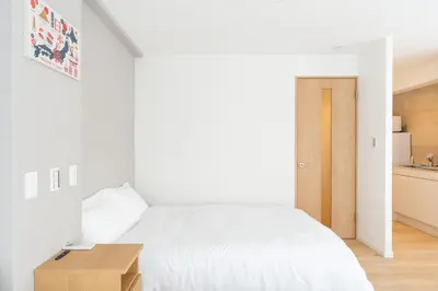 a bedroom with a white bed and a wooden table at \u79cb\u8449\u539f\u307e\u30677\u5206 \u6d45\u8349\u6a4b\u307e\u30674\u5206 \u79cb\u8449\u539f7\u5206 \u6d45\u8349\u6a4b4\u5206 \u30ad\u30c3\u30c1\u30f3 \u9326\u7cf8\u753a\u99c5\u8fd1 \u6d17\u9762\u53f0\u30b7\u30e3\u30ef\u30fc\u5ba4\u304c\u5225 \u30bb\u30df\u30c0\u30d6\u30eb\u30d9\u30c3\u30c9\u4e8c\u3064 301\u90e8\u5c4b in Tokyo
