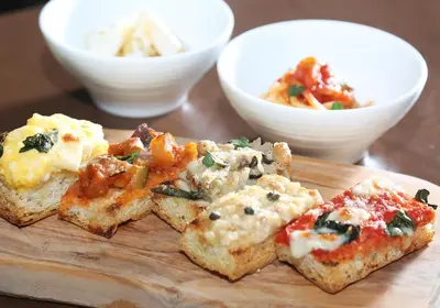 a wooden cutting board topped with pieces of food on a table at Daiwa Roynet Hotel Ginza PREMIER in Tokyo