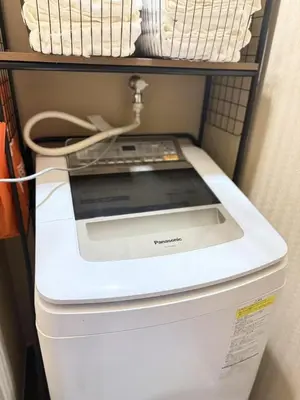 a washing machine sitting on top of a refrigerator at aiki house in Tokyo