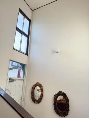 a white wall with two mirrors and a door at aiki house in Tokyo