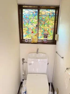 a bathroom with a toilet with a stained glass window at aiki house in Tokyo