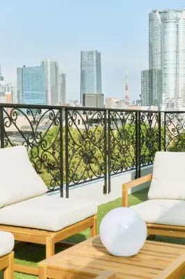 a balcony with two chairs and a table with a view at IoTele Minami-Aoyama in Tokyo