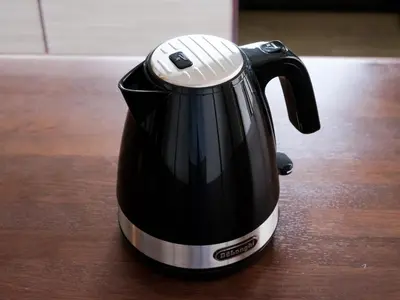 a black electric kettle sitting on a wooden table at ESTABLISHMENT Ueno in Tokyo