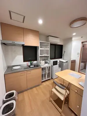 a kitchen with a wooden table and a desk with a tableablish at Askusa\u4f4f\u5409\u9928 \u6d45\u8349\u8fd1\u304f\u7573\u306e\u548c\u5ba4\u5bb6\u65cf\u3084\u30b0\u30eb\u30fc\u30d7\u306b\u3074\u3063\u305f\u308a\u306e\u90e8\u5c4b\u4e0a\u91ce\u79cb\u8449\u539f\u9280\u5ea7\u516d\u672c\u6728\u99c5\u76f4\u901a in Tokyo
