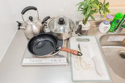 a kitchen counter with a frying pan on a sink at Askusa\u4f4f\u5409\u9928 \u6d45\u8349\u8fd1\u304f\u7573\u306e\u548c\u5ba4\u5bb6\u65cf\u3084\u30b0\u30eb\u30fc\u30d7\u306b\u3074\u3063\u305f\u308a\u306e\u90e8\u5c4b\u4e0a\u91ce\u79cb\u8449\u539f\u9280\u5ea7\u516d\u672c\u6728\u99c5\u76f4\u901a in Tokyo