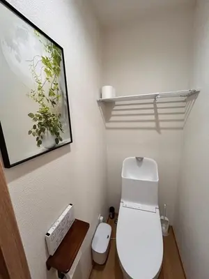 a bathroom with a toilet and a picture on the wall at Askusa\u4f4f\u5409\u9928 \u6d45\u8349\u8fd1\u304f\u7573\u306e\u548c\u5ba4\u5bb6\u65cf\u3084\u30b0\u30eb\u30fc\u30d7\u306b\u3074\u3063\u305f\u308a\u306e\u90e8\u5c4b\u4e0a\u91ce\u79cb\u8449\u539f\u9280\u5ea7\u516d\u672c\u6728\u99c5\u76f4\u901a in Tokyo