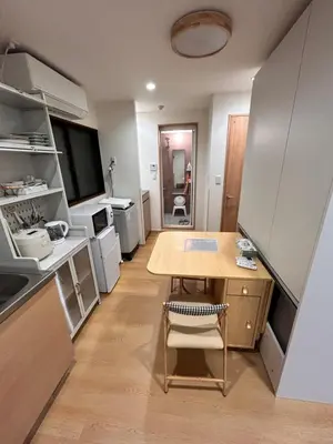 a small kitchen with a wooden table and a dining room at Askusa\u4f4f\u5409\u9928 \u6d45\u8349\u8fd1\u304f\u7573\u306e\u548c\u5ba4\u5bb6\u65cf\u3084\u30b0\u30eb\u30fc\u30d7\u306b\u3074\u3063\u305f\u308a\u306e\u90e8\u5c4b\u4e0a\u91ce\u79cb\u8449\u539f\u9280\u5ea7\u516d\u672c\u6728\u99c5\u76f4\u901a in Tokyo