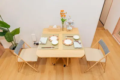 a dining room table with two chairs and a table and chairs at Askusa\u4f4f\u5409\u9928 \u6d45\u8349\u8fd1\u304f\u7573\u306e\u548c\u5ba4\u5bb6\u65cf\u3084\u30b0\u30eb\u30fc\u30d7\u306b\u3074\u3063\u305f\u308a\u306e\u90e8\u5c4b\u4e0a\u91ce\u79cb\u8449\u539f\u9280\u5ea7\u516d\u672c\u6728\u99c5\u76f4\u901a in Tokyo