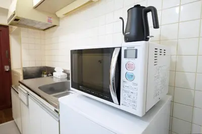 a microwave sitting on a counter in a kitchen at Heisei Mansion - Vacation STAY 19183 in Tokyo