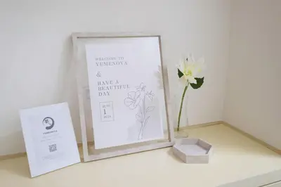 a picture frame on a table with a vase of flowers at Heisei Mansion - Vacation STAY 19183 in Tokyo