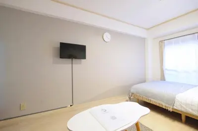 a bedroom with a bed and a tv on the wall at Heisei Mansion - Vacation STAY 19183 in Tokyo