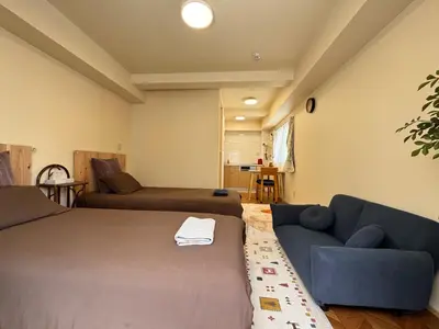 a living room with two beds and a couch at \u4e1c\u4eac#2\u6574\u5957\u623f\u6e90\u8fd1\u6c60\u888b\u65b0\u5bbf\u72ec\u7acb\u6d17\u624b\u95f4\u53a8\u623f\u53cc\u5e8a\u53ef\u4f4f2\u52303\u4eba in Tokyo