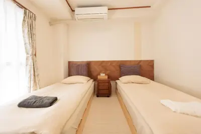 two twin beds in a room with a window at \u4e1c\u4eac#3\u6574\u5957\u623f\u6e90\u8fd1\u6c60\u888b\u65b0\u5bbf\u72ec\u7acb\u6d17\u624b\u95f4\u53a8\u623f\u53cc\u5e8a\u53ef\u4f4f2\u52303\u4eba in Tokyo