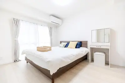 a white bedroom with a bed and a window at Iriya House\u5165\u8c37\u516c\u5bd3702 in Tokyo
