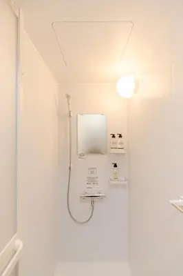 a bathroom with a shower and a mirror on the wall at Iriya House\u5165\u8c37\u516c\u5bd3702 in Tokyo