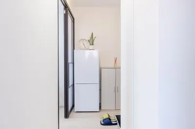 an open door to a kitchen with a refrigerator at Iriya House\u5165\u8c37\u516c\u5bd3702 in Tokyo