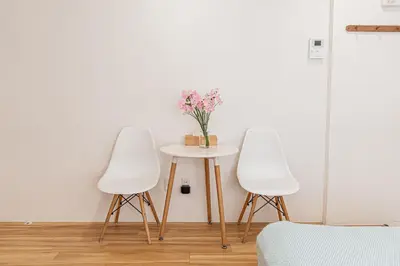 two white chairs and a table with a vase of flowers at \u65c5\u5c4b \u8981\u753a\u516c\u5bd3,\u65e0\u7535\u68af in Tokyo