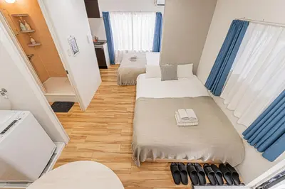 two beds in a small room with blue curtains at \u65c5\u5c4b \u8981\u753a\u516c\u5bd3,\u65e0\u7535\u68af in Tokyo