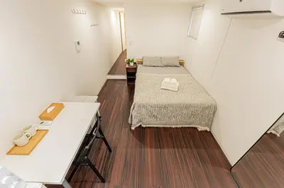 two beds in a small room with wooden floors at \u65c5\u5c4b \u8981\u753a\u516c\u5bd3,\u65e0\u7535\u68af in Tokyo