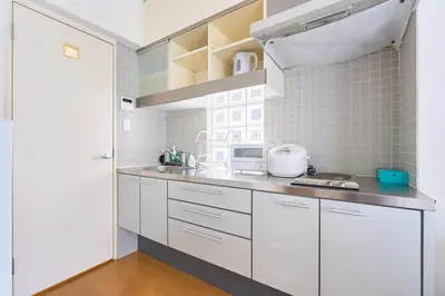 a kitchen with white cabinets and a counter top at 3B SHIBUYA Cozy Bright Apartment, 28sqm, free wifi, MAX 5PP in Tokyo