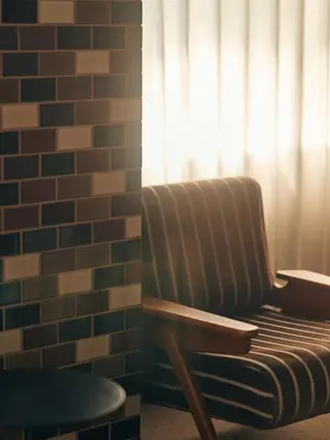 a chair sitting next to a brick wall with a window at illi Pal Shinagawa Gotanda in Tokyo
