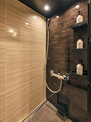 a bathroom with a shower with a wooden wall at illi Pal Shinagawa Gotanda in Tokyo