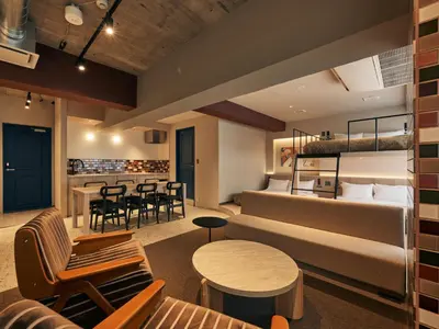 a hotel room with a couch and a table and chairs at illi Pal Shinagawa Gotanda in Tokyo