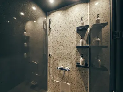 a bathroom with a shower with a glass door at illi Tria Shibuya in Tokyo
