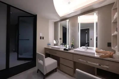 a bathroom with two sinks and a white chair at HOTEL MINATO Azabu-juban in Tokyo