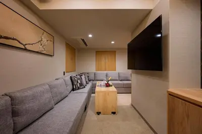 a living room with a gray couch and a tv at HOTEL MINATO Azabu-juban in Tokyo
