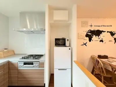 a small kitchen with a refrigerator and a table at Sun inn \u4eac\u5cf6 in Tokyo