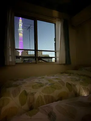 a bedroom with a window with a view of a lighthouse at Sun inn \u4eac\u5cf6 in Tokyo