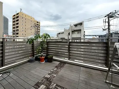 a balcony with potted plants on top of a building at Sun inn \u4eac\u5cf6 in Tokyo