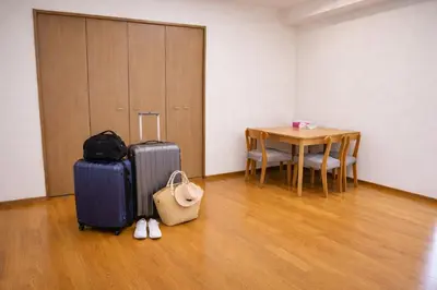 a room with a table and a suitcase and a table and chairs at 7th floor 702 with elevator, Minato area, 40 square meters, near Tokyo Tower, direct train to Haneda Airport, Narita Airport in Tokyo