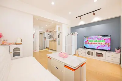 a white living room with a tv and a kitchen at Jr\u5c71\u624b\u7dda\u6c60\u888b\u99c5\u5f92\u6b656\u5206\u5168\u65b0\u88c5\u4fee\u4e24\u5c45\u5ba4\u516c\u5bd3 in Tokyo