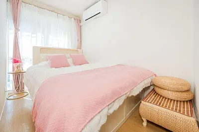 a bedroom with a bed with pink sheets and a window at Jr\u5c71\u624b\u7dda\u6c60\u888b\u99c5\u5f92\u6b656\u5206\u5168\u65b0\u88c5\u4fee\u4e24\u5c45\u5ba4\u516c\u5bd3 in Tokyo