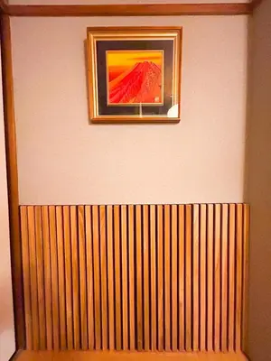 a picture hanging on a wall above a wooden fence at Unique house mixed Japanese and European old style in Tokyo