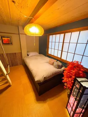 a bedroom with a bed in a room with windows at Unique house mixed Japanese and European old style in Tokyo