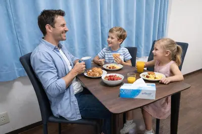 a man and two children sitting at a table eating food at 7th floor 701 with elevator 40 square meters in the port area, close to Tokyo Tower, direct access to Haneda Airport in Tokyo