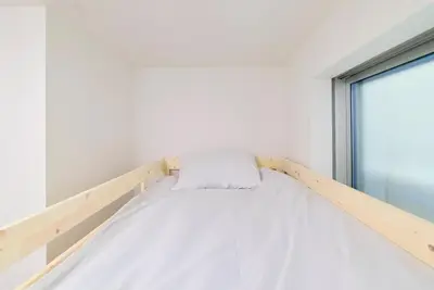 a bed in a white room with a window at Yodamari House Ikebukuro Direct access to Shinjuku and Shibuya7 people OK! in Tokyo