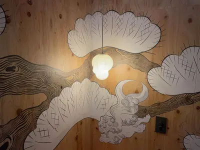 a painting of a tree on the wall of a room at SUNPIKA Tokyo in Tokyo
