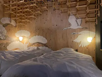a bedroom with two beds with white birds on the wall at SUNPIKA Tokyo in Tokyo