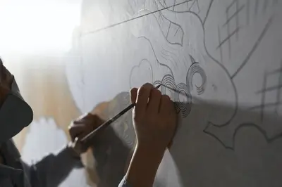 a person writing on a wall with a paintbrush at SUNPIKA Tokyo in Tokyo
