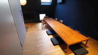 a long wooden table in a room with chairs at SUNPIKA Tokyo in Tokyo