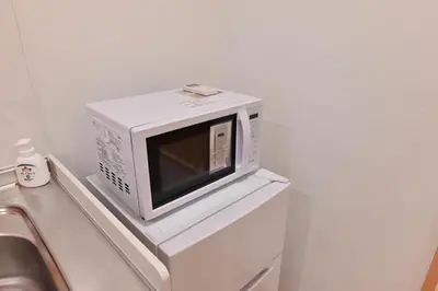 a microwave sitting on top of a white refrigerator at Skytree Luxury Villa - 2025 New, to Skytree, Direct Airport Access in Tokyo
